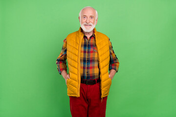Fototapeta premium Photo of pretty charming senior gentleman wear yellow vest walking smiling isolated green color background
