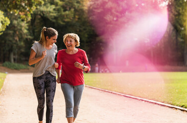 Granddaughter and grandmother having fun, jogging together in the park