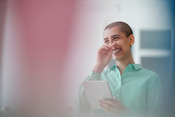 Portrait of a laughing woman holding tablet