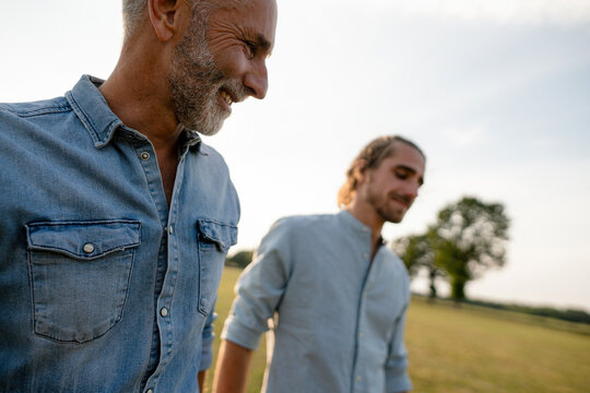 Happy father with adult son on a meadow in the countryside