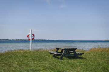 Empty picnic table and pole with life belt