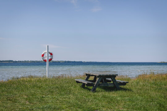 Empty picnic table and pole with life belt