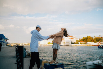 a man and a woman in love at sunset, on the sea embankment