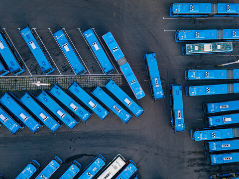 Aerial view of parking lot filled with blue buses