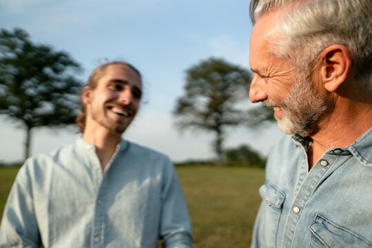 Happy Father With Adult Son On A Meadow In The Countryside