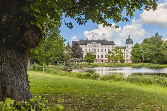 Germany, Schleswig-Holstein, Fargau-Pratjau, Salzau stream flowing through public park with Gut Salzau mansion in background