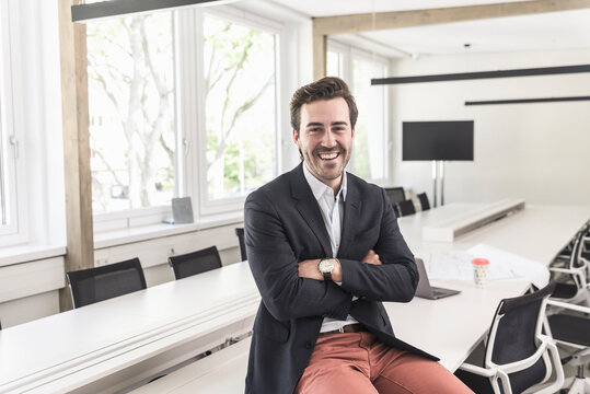 Confident sitting in boardroom with armd crossed
