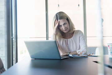 Stressed businesswoman using laptop in office