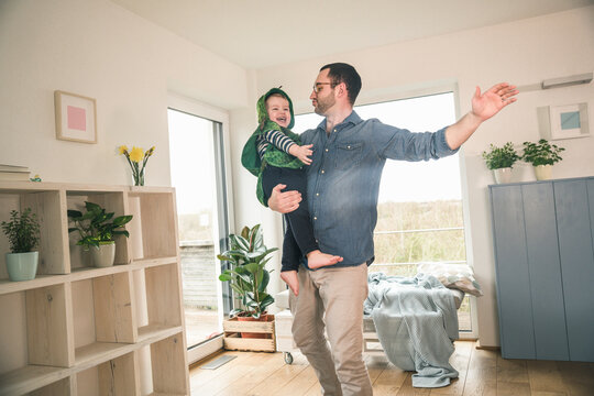 Father playing with happy son in a costume at home
