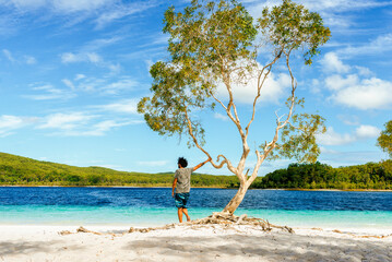 Man looking at Lake Mckenzie against sky, Fraser Island, Queensland, Australia - obrazy, fototapety, plakaty
