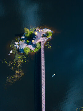 Russia, Leningrad Oblast, Aerial view of paddleboarder passing Church of Saint Andrew at Vuoksa
