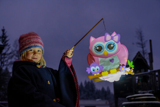 Portrait of proud little girl with paper lantern in the evening