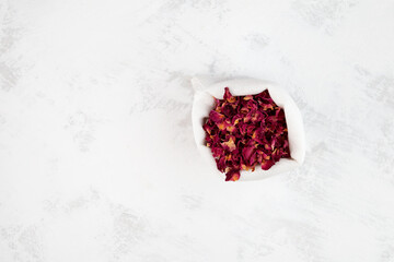 Dried rose petals in white pouch, top view. Selective focus, copy space