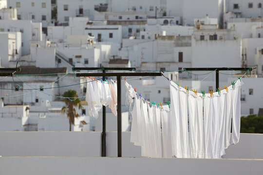 Spain, Andalusia, Conil de la Frontera, drying clothes with building in background