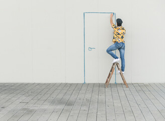Digital composite of young man drawing a door at a wall