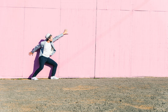Young man in front of pink construction barrier, feeling trapped