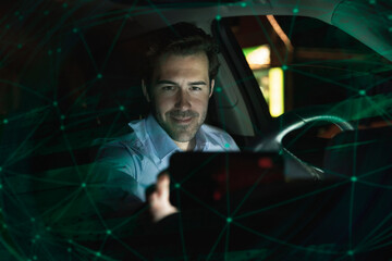 Businessman using navigation device in car at night
