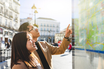 Spain, Madrid, young couple looking at the map and exploring the city
