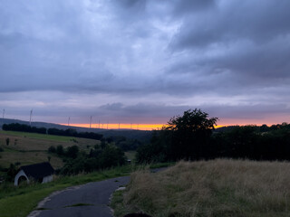 Landschaft Windräder Wald Feldweg bei Sonnenuntergang