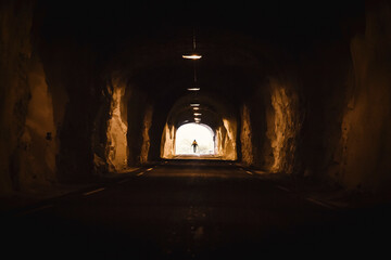 Norway, Lofoten Islands, Maervoll, silhouette of man at the end of a tunnel