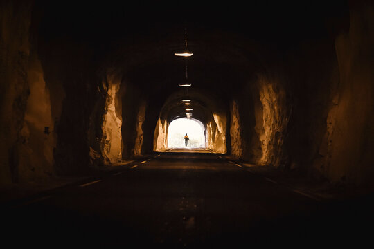 Norway, Lofoten Islands, Maervoll, silhouette of man at the end of a tunnel
