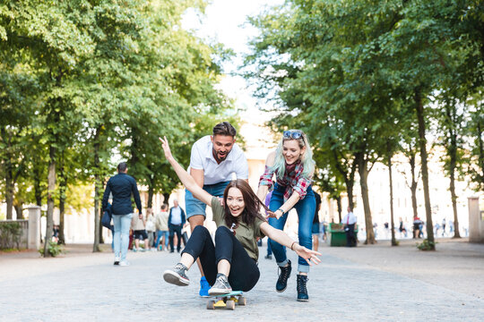 Group of three friends having fun with skateboard