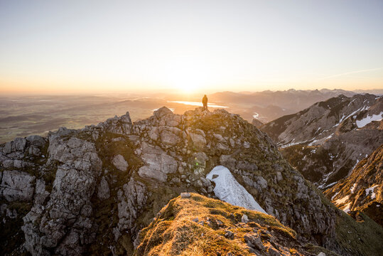 Hiker on viewpoint during sunset, Aggenstein, Bavaria, Germany