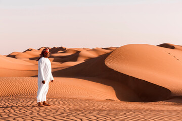 Bedouin in National dress standing in the desert, Wahiba Sands, Oman