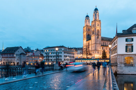 Switzerland, Zurich, Grossmunster church and Munsterbrucke over Limmat river at dusk