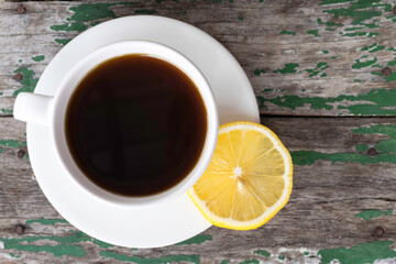 Black coffee and lemon on old wooden background.