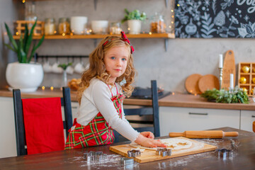little girl making cookies for christmas in the kitchen
