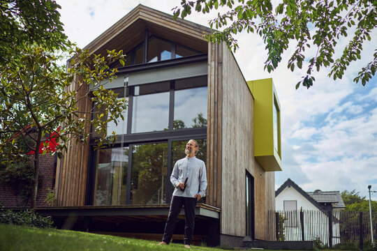 Mature Man With Beer Bottle While Standing Outside Modern Tiny House