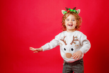 little girl in deer horns on a red background, christmas, new year