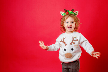 little girl in deer horns on a red background, christmas, new year