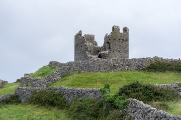Obraz premium old castle ruin of a tower on a green grass hill on the Aran Islands