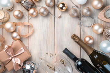 Champagne, Christmas balls and a gift on a beige background.