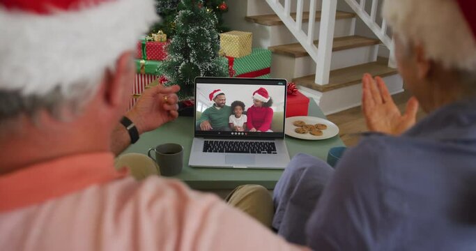 Happy african american senior couple on video call with family at christmas