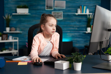 Tired bored schoolchild studying elementary literature doing school homework using e-learning educational platform sitting at desk in living room. Exhausted little kid having online mathematics lesson