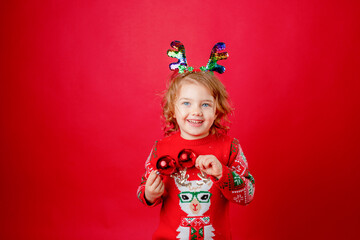 little girl Christmas deer horns red background, new year.