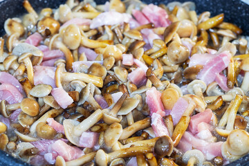 Close-up of a frying pan with meat and mushrooms. Cooking concept, selective focus
