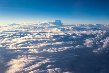 A mass of cumulus, wavy clouds in the Earth's atmosphere. A view from above. A view of the clouds from an aircraft window.