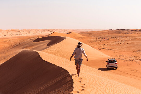 Man walking on a sand dune, Wahiba Sands, Oman