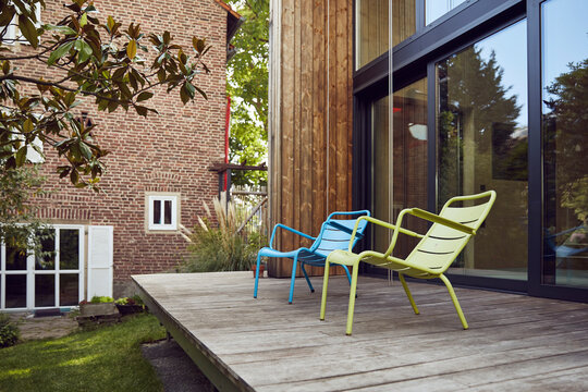Empty chairs on hardwood floor outside tiny house