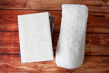 Notepad with a copy space for text, a stack of books and a warm sweater beside