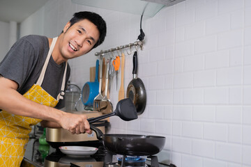 Asian chef fried eggs on pan to thai food in kitchen on gas stove The oil in pan boiling.Eggs and pork cooked. before serving to happy family to eat togetherness in home