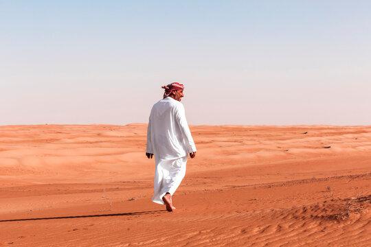 Bedouin walking in the desert, Wahiba Sands, oman