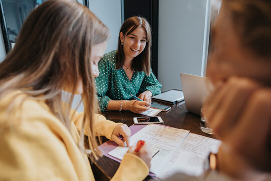 Teenage girls studying and learning from home, assisting eachother