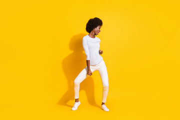 Fototapeta na wymiar Full size photo of optimistic cool short hair lady dance wear white pullover trousers sneakers isolated on yellow background