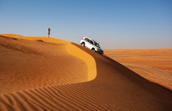 Man with off-road vehicle, taking pictures in the desert, Wahiba Sands, Oman