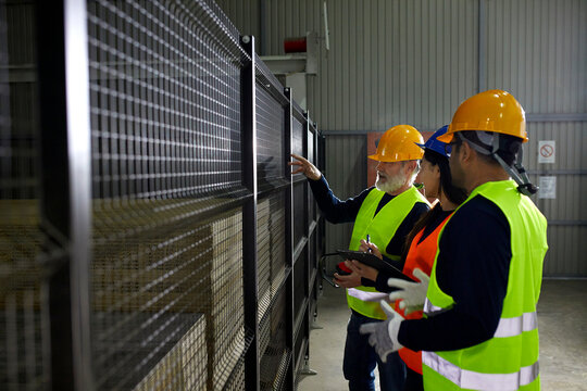 Workers standing at grid in factory talking